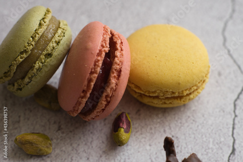 Colorful macarons and pistachios isolated. French meringue cookie macaron.