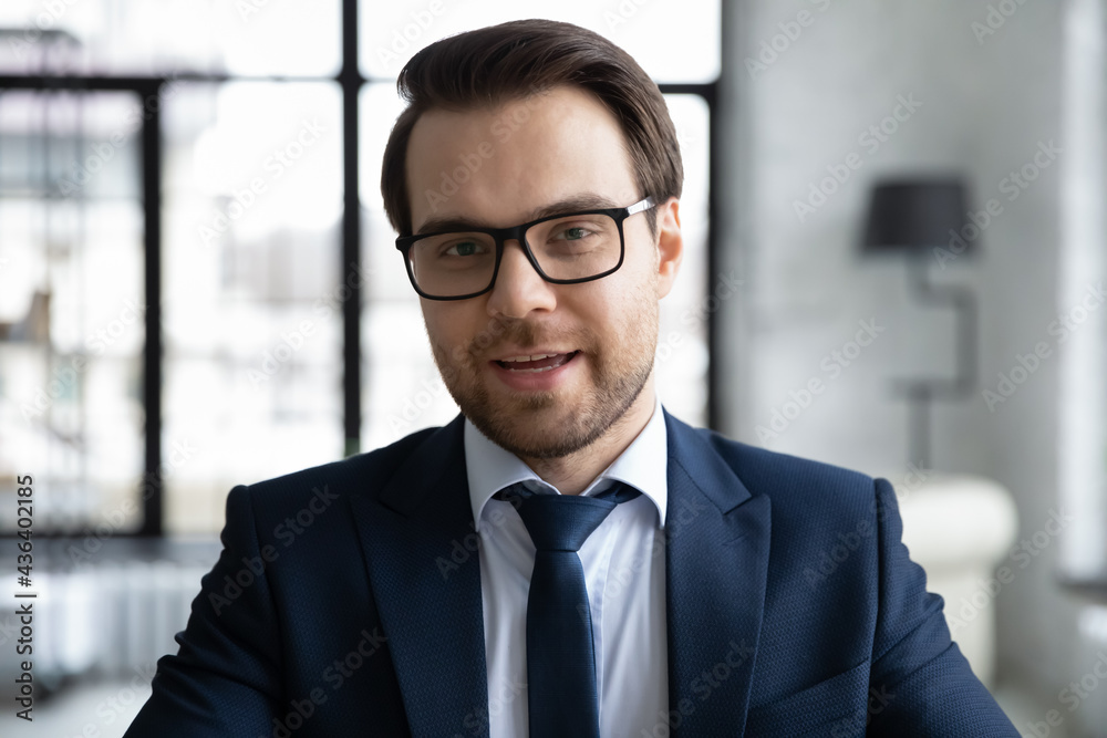 Fototapeta premium Confident business coach holding online training, webinar. Portrait of 30s businessman, professional wearing glasses and formal suit, looking at camera and speaking. Head shot, video call screen view