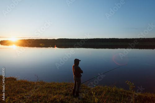 A fisherman by the river in the evening.