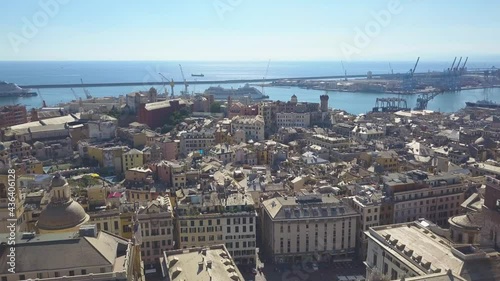 Aerial panoramic drone view of buildings and streets surrounding Port of Genoa.Old famous city of Italy, with beautiful architecture, houses, roofs, buildings.Cruise ships and ferries in port.4K video photo