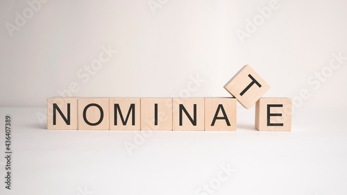The word nominate is written on wooden cubes on a light background. Business concept photo