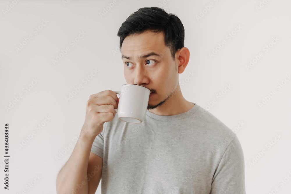 Asian man is drinking coffee or tea isolated on white background. Asian man is drinking coffee or tea isolated on white background.