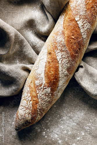 Baguette, traditional bread on linen fabric, close-up view