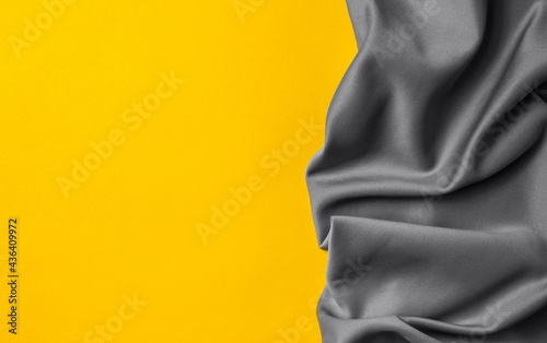 Bright trending yellow background with gray fabric. Top view. Minimalism concept. Perfect for presentations, decor.