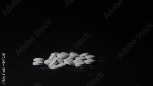 Close up picture of a vitamin C tablet with a black background