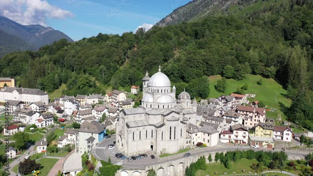 General view of picturesque Re village in green Italian Alps in sunny summer day looking out over pilgrimage Sanctuary of Madonna del Sangue 