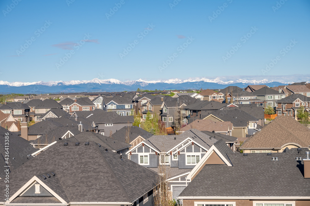 Roof top view of modern suburban home in Calgary with mountain in the background. Roof top view of modern suburban home in Calgary with mountain in the background.