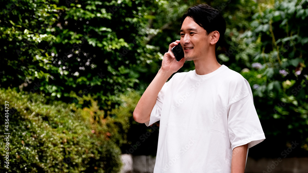 スマホで通話する白いシャツの男性 スマホで通話する白いシャツの男性