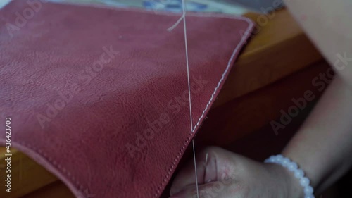 Leather bag sewing by handmade with thread crafmanship working photo