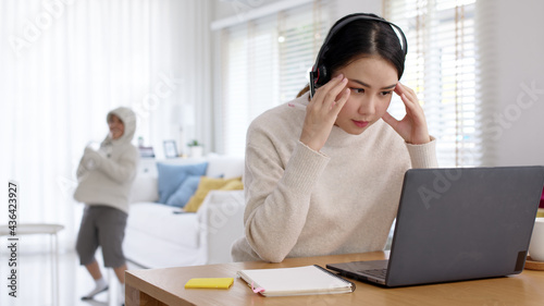 фотографія Work at home problem of asian woman employee work remotely talk on video call conference meeting at home office and kids interruption breakout behind in self quarantine social distance coronavirus