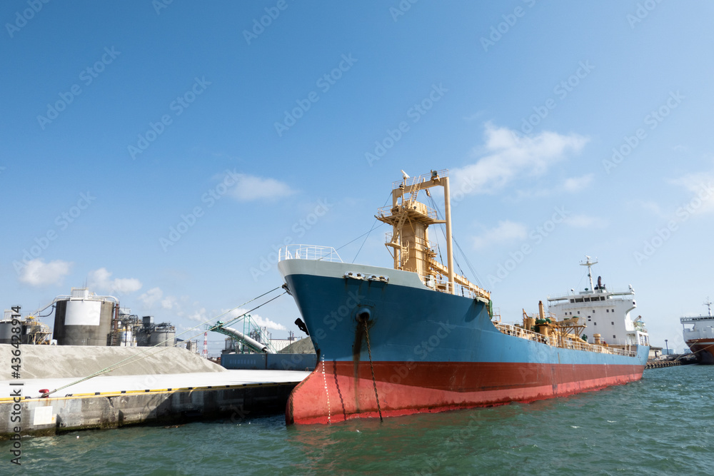 Cargo ship anchored in port. Blue Sky Background
