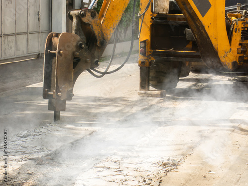 Machine is working to drill the concrete pavement Causing dust smoke and noise pollution The operation of the machine to drill road surface