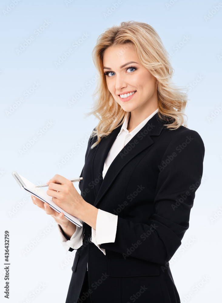 Portrait of young beautiful businesswoman with clipboard writing, on blue background. Success in business, job and education concept. Portrait of young beautiful businesswoman with clipboard writing, on blue background. Success in business, job and education concept.