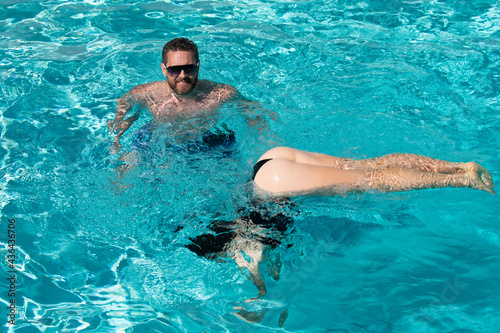 Couple summertime vacation. Life winner. Butt in bikini. Sexy couple in pool.