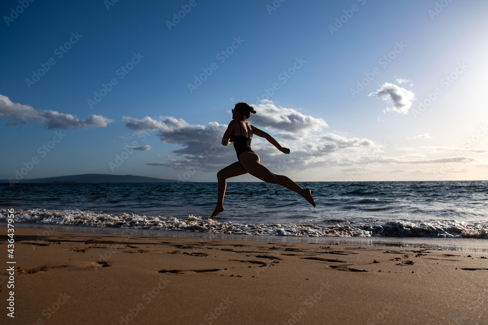 Outdoor sports. Woman running along the sea shore in morning. Fitness female doing running exercise on the beach. Outdoor sports. Woman running along the sea shore in morning. Fitness female doing running exercise on the beach.