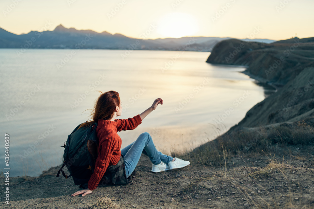 a traveler with a backpack on the sand relaxes in nature near the sea in the mountains