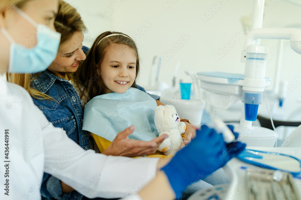 Oral hygienist with jaw model teaching patients to brush teeth properly to prevent caries. Oral hygienist with jaw model teaching patients to brush teeth properly to prevent caries.