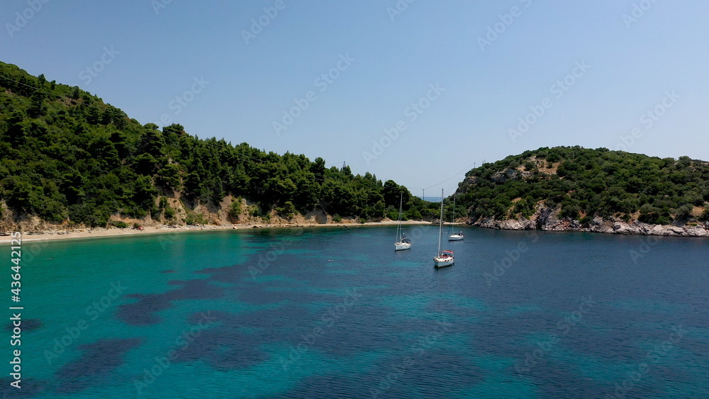 Drone aerial view of tourists enjoying a paradise luxury Yacht trip around Skopelos island, Greece, Aegean Sea, Europe.