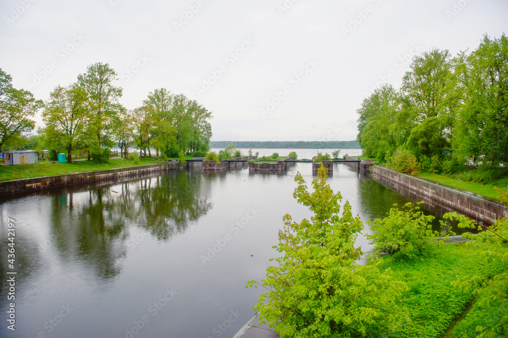 Old historical gateways in the city of Shlisselburg. Landscape of the summer water royal canal. Old historical gateways in the city of Shlisselburg. Landscape of the summer water royal canal.