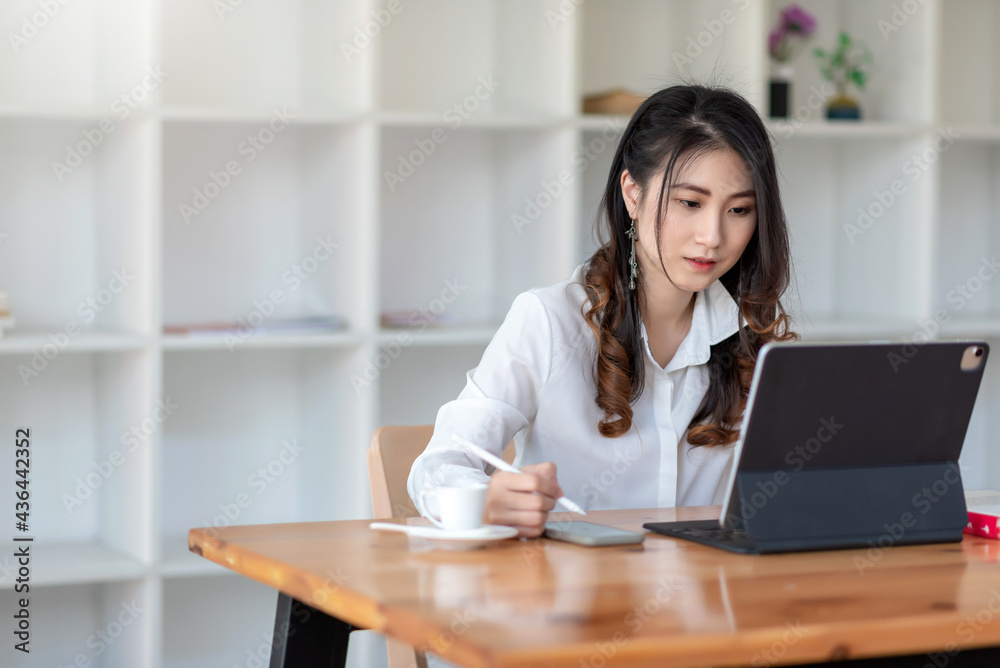 Young businesswoman sitting at the office using a tablet and smartphone put at office. Young businesswoman sitting at the office using a tablet and smartphone put at office.