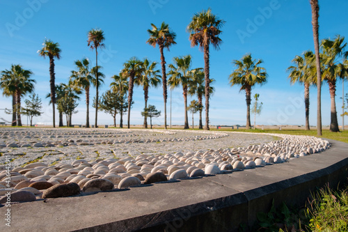 Decorative pebble stone path with blurred background of sea side park, selective focus photo