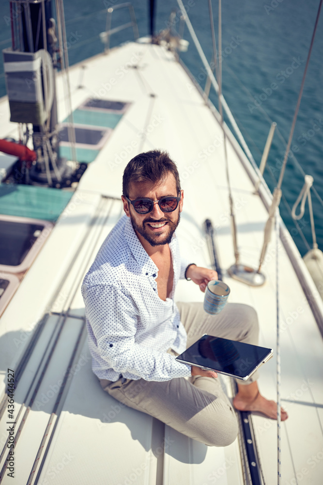 Casual businessman working remotely from the yacht