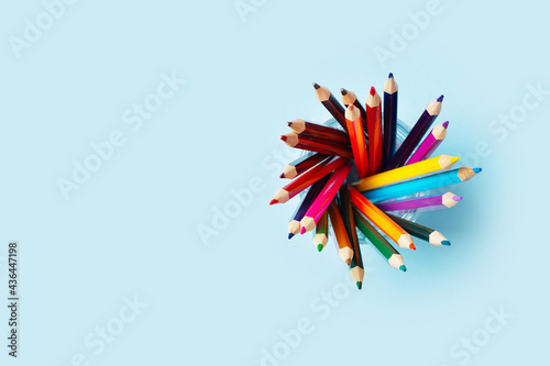 Colorful pencils above on blue background, back to school theme
