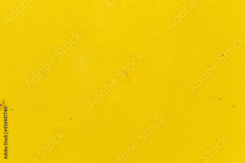 Old iron door painted in bright yellow close-up, for design
