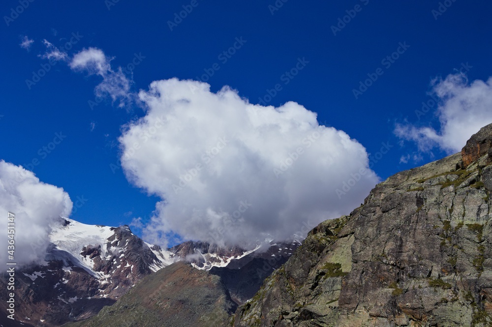 Big clouds above snow capped peaks of mountains in the italian Alps (Trentino, Italy, Europe) Big clouds above snow capped peaks of mountains in the italian Alps (Trentino, Italy, Europe)
