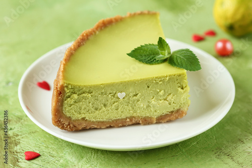 Сlose-up of  homemade freshly baked  lemon cheesecake against green background, dessert concept, selective focus.