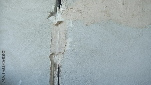 Unrecognizable man plastering concrete wall with wire