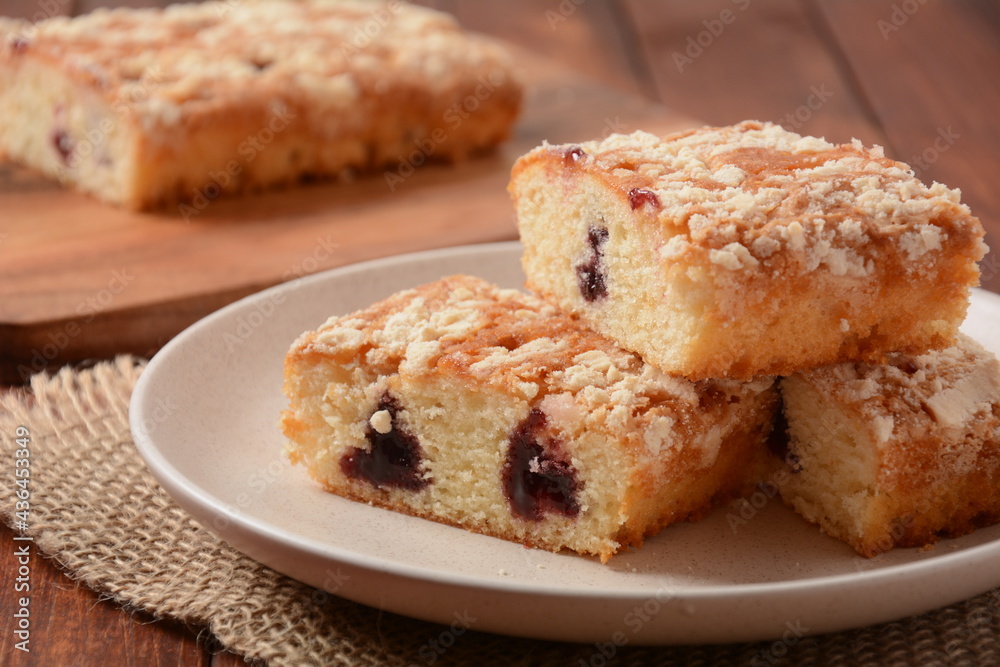 German cherry cake with vanilla and icing sugar, with glaze, served and sliced on plate