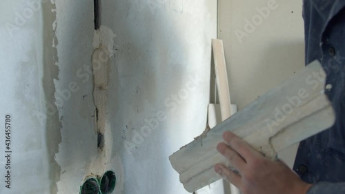 Unrecognizable man plastering concrete wall with wire