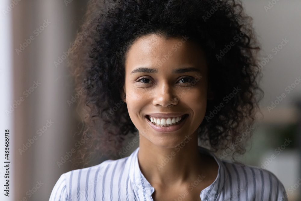 Close up profile picture of smiling young African American woman look at camera feel confident successful. Headshot portrait of happy millennial mixed race female renter or tenant. Diversity concept. Close up profile picture of smiling young African American woman look at camera feel confident successful. Headshot portrait of happy millennial mixed race female renter or tenant. Diversity concept.