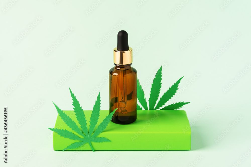Cannabis oil extract in droplet bottle on green background. Medical marijuana cbd oil. Cannabis oil extract in droplet bottle on green background. Medical marijuana cbd oil.