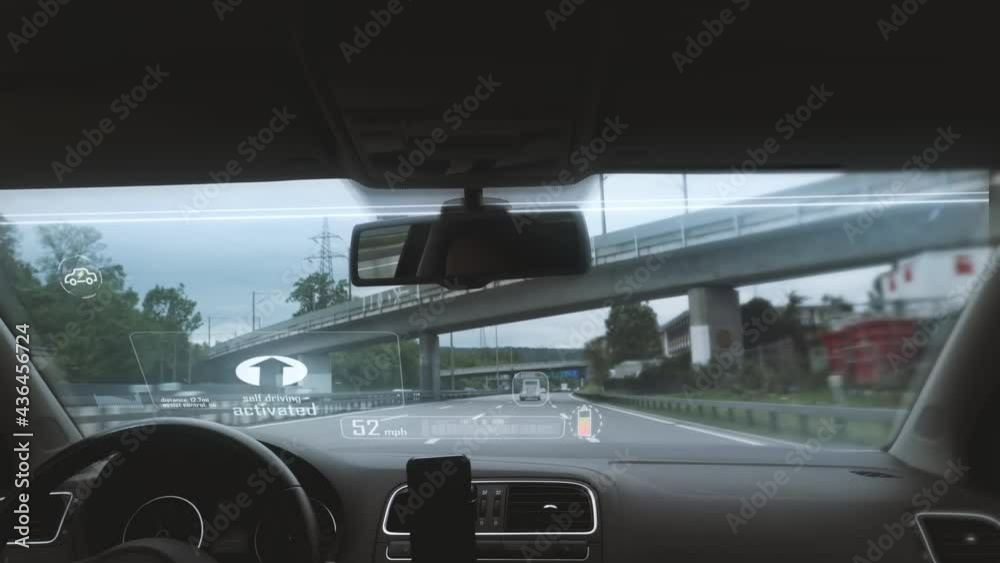 Interior view of self-driving electric car system with digital HUD screen windshield. Autonomous futuristic driving on expressway