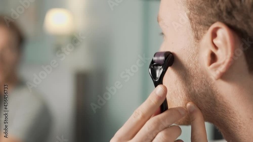 Close-up of a mesoroller massaging a man's beard photo
