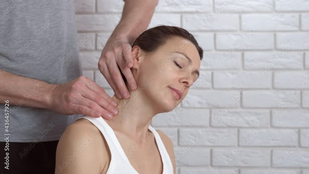 Relaxation neck massage for woman. A view of a man hand's making a neck massage to his woman in the room. Relaxation neck massage for woman. A view of a man hand's making a neck massage to his woman in the room.