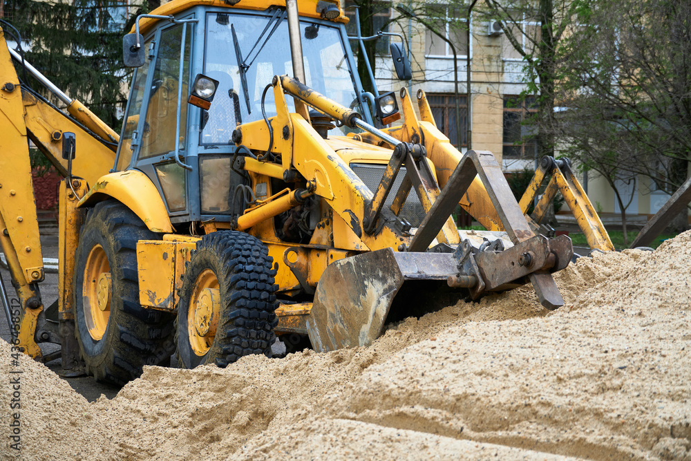 tractor or bulldozer works with a pile of sand for construction