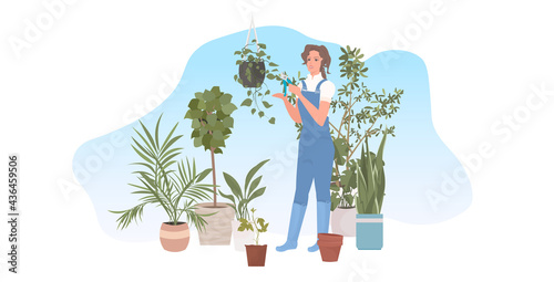 female gardener using pruners cutting houseplants garden work with branches and foliage