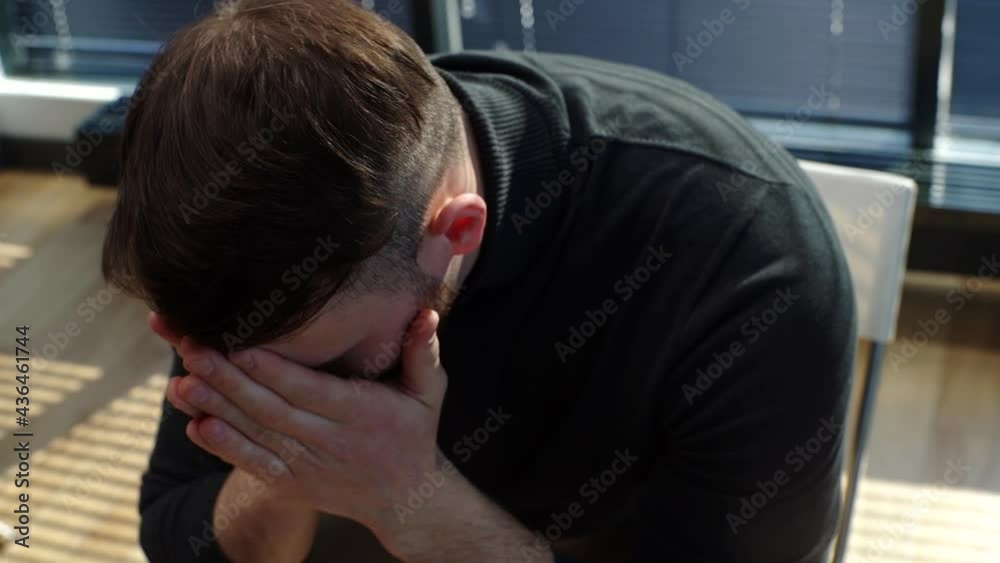 Close-up face of crying desperate young man sharing problem sitting in circle during group interpersonal therapy session. Sad depressed male talking with compassionate patients and psychotherapist. Close-up face of crying desperate young man sharing problem sitting in circle during group interpersonal therapy session. Sad depressed male talking with compassionate patients and psychotherapist.