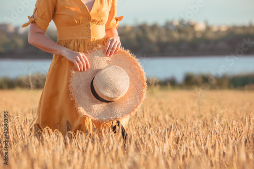 Canvas Print woman in yellow sundress walking by wheat field