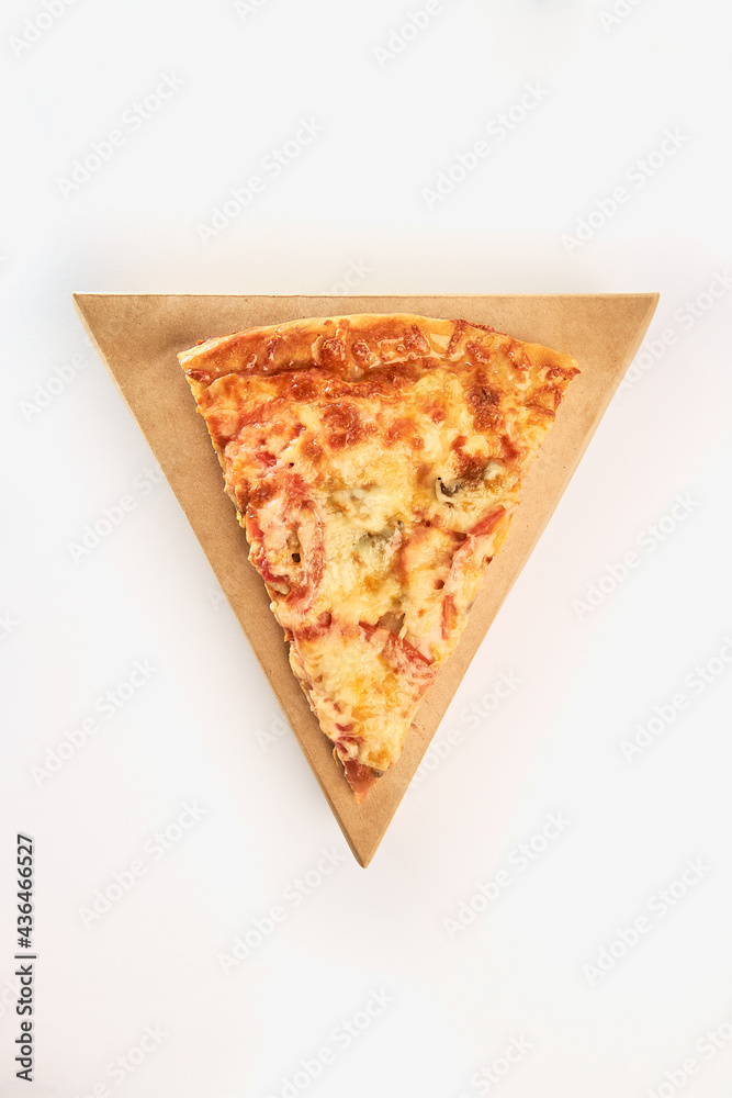 Fototapeta One slice of pizza with mushrooms, tomatoes and cheese on a triangular cardboard box on a white background.