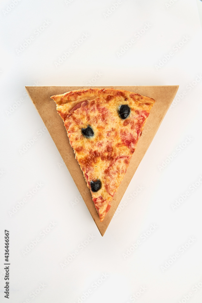 Fototapeta One slice of pizza with olives, sausage and cheese on a triangular cardboard box on a white background.