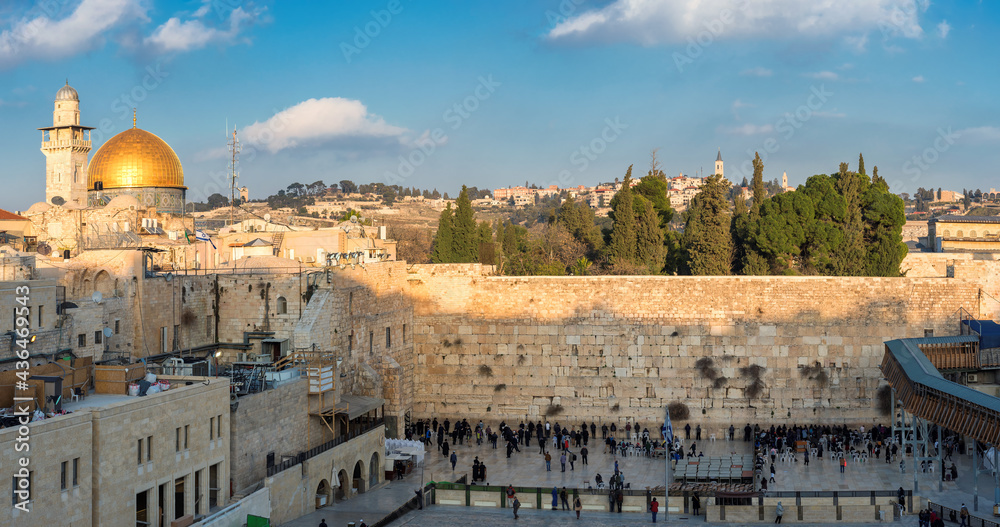Obraz premium Panoramic view in the old city of Jerusalem at sunset, including the Western Wall and golden Dome of the Rock. 