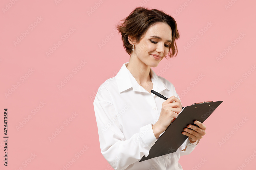 Young happy successful employee business secretary woman corporate lawyer in classic formal white shirt work in office clipboard with papers write document isolated on pastel pink background studio Young happy successful employee business secretary woman corporate lawyer in classic formal white shirt work in office clipboard with papers write document isolated on pastel pink background studio