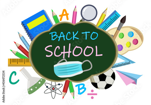 Green chalk board with wording Back to school and colorful classroom or study accessories to welcome back for new semester with face mask to protect from Coronavirus or COVID 19