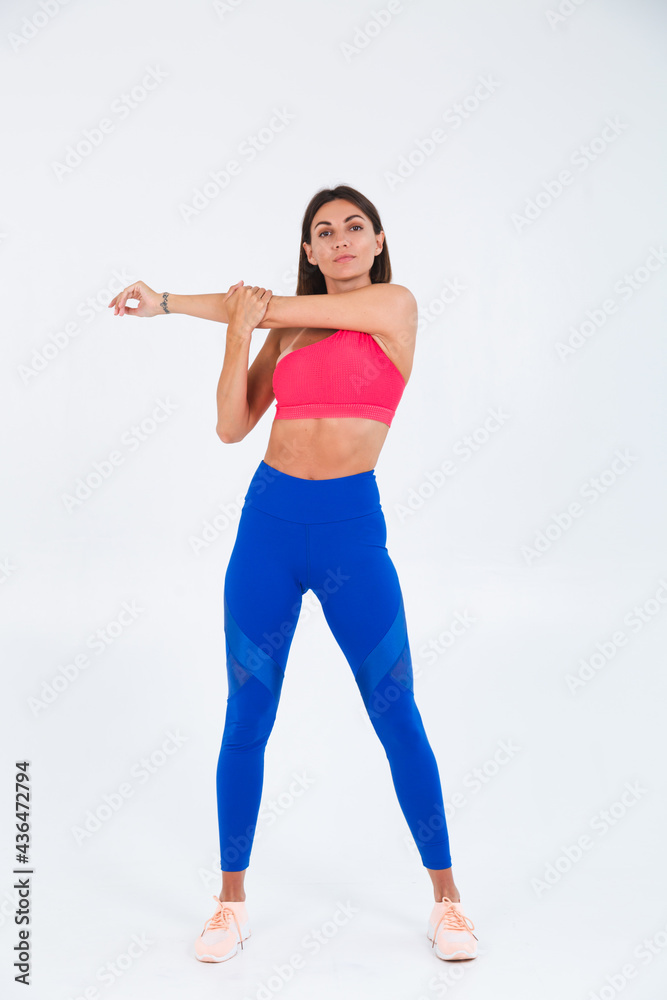 Fit tanned sporty woman with abs, fitness curves, wearing top and blue leggings on white background Fit tanned sporty woman with abs, fitness curves, wearing top and blue leggings on white background