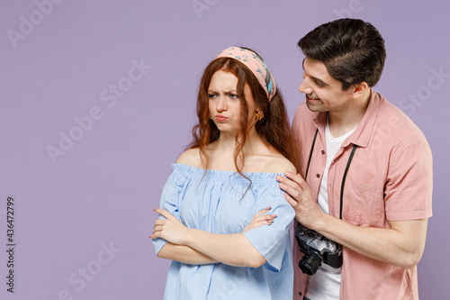 Two frowning indignant traveler tourist woman man couple in casual clothes try to hug apologise isolated on purple background. Passenger travel abroad on weekends getaway. Air flight journey concept