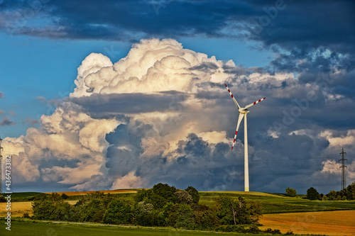 wind turbine in the field with big stormy clouds